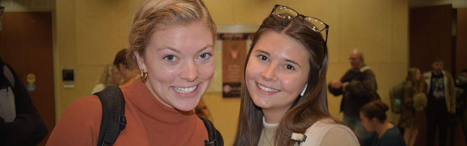 two students standing near each other smiling